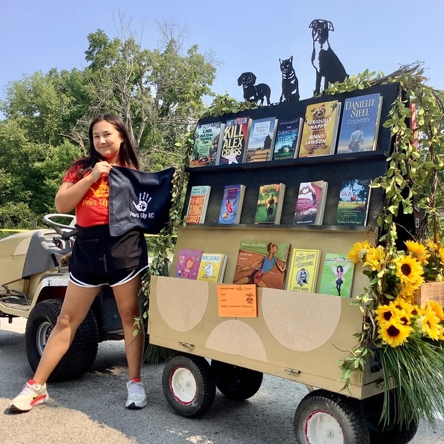 Halley Vincent in front of the Paws Up KC bookmobile, which was a modified lawnmower.